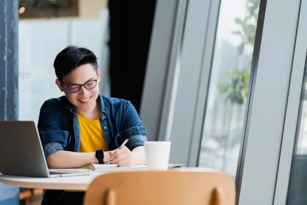 A man smile happily while writing something