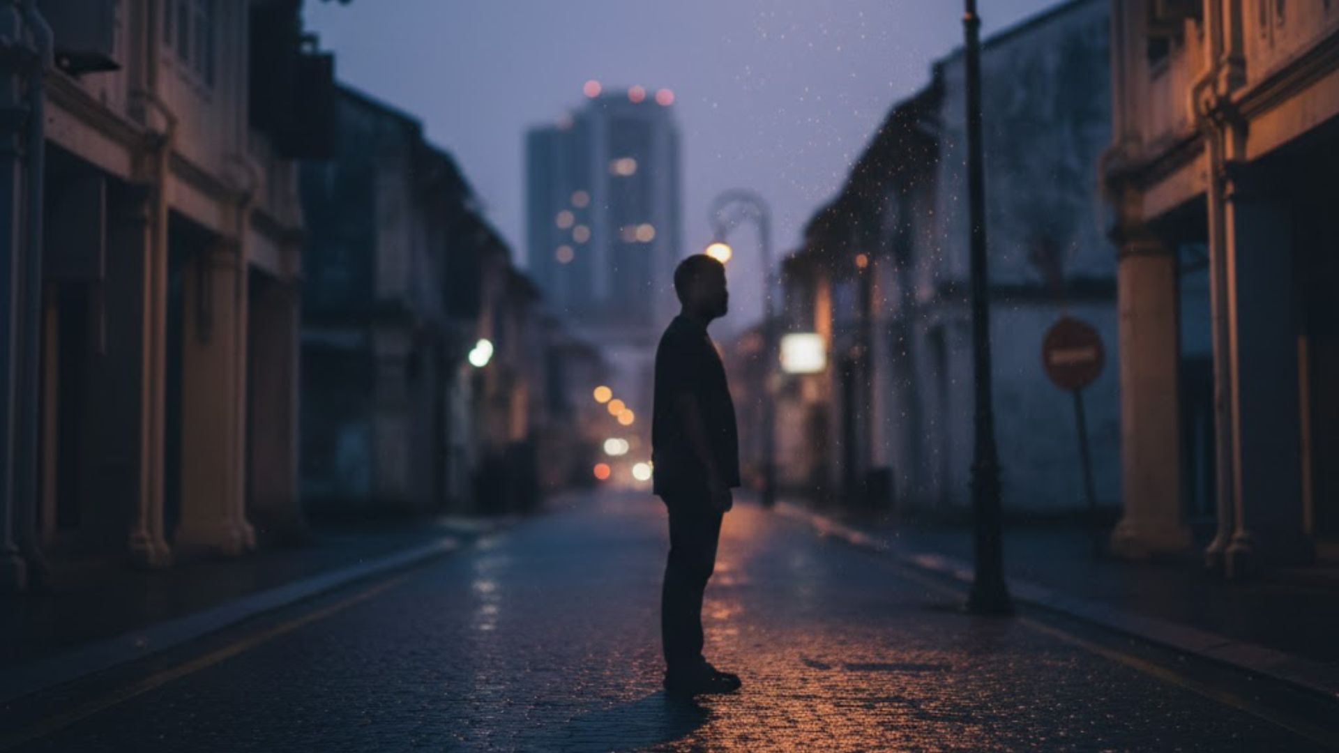 A silhouette in the distance under a streetlamp.