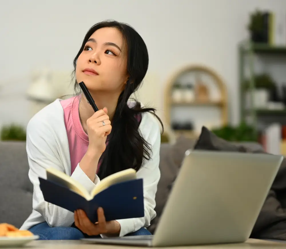 An Asian girl thinking something in her book