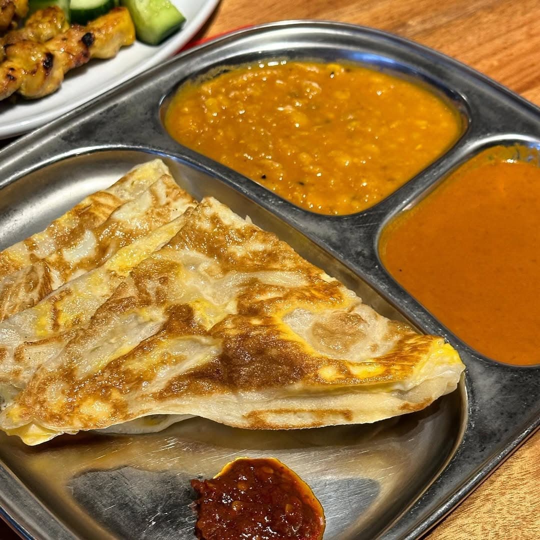 Indian cuisine: roti telur at a mamak, served with dhal, curry gravy and sambal.